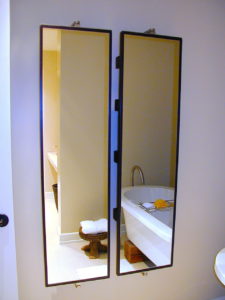 #290 Pair of Swivel Mirrors for the bathroom.  Stainless steel wall mounting hardware that holds the mirrors in place and allows them to swivel.  Mahogany shelves mounted on the reverse side of the mirror for storing bottles. 