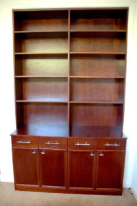 #357 Build-in Bookcase This unit is built in the opening of a closet to appear as though it is only a niche in the wall.  Adjustable shelves in the upper section, 4 drawers with full extension metal drawer slides and one fixed shelf behind the four doors on the bottom unit.  80"H x 54"W x 22"D (bottom) 12"D (top) Finish: Mahogany stain and satin lacquer